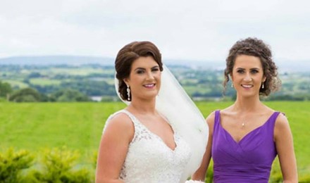Bride and Bridesmaid standing for a picture on here wedding day. Makeup and wedding dress on.  Co Sligo