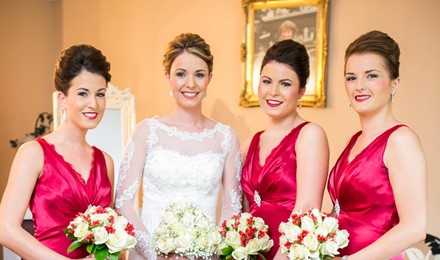 beautiful bride in her wedding dress along side 4 bridesmaids red raspberry dresses with a lipstick to match. Stunning makeup flawless finish, 